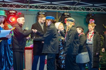 udekorowany skwer, scena, występy, osoby biorące udział w spotkaniu, poczęstunek, karuzela, żywa szopka