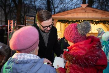 udekorowany skwer, scena, występy, osoby biorące udział w spotkaniu, poczęstunek, karuzela, żywa szopka