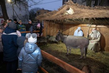 udekorowany skwer, scena, występy, osoby biorące udział w spotkaniu, poczęstunek, karuzela, żywa szopka
