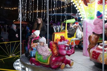 udekorowany skwer, scena, występy, osoby biorące udział w spotkaniu, poczęstunek, karuzela, żywa szopka