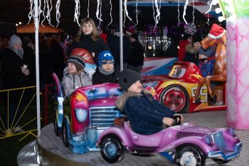 udekorowany skwer, scena, występy, osoby biorące udział w spotkaniu, poczęstunek, karuzela, żywa szopka