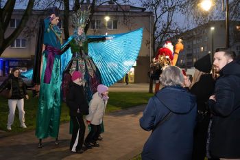 udekorowany skwer, scena, występy, osoby biorące udział w spotkaniu, poczęstunek, karuzela, żywa szopka