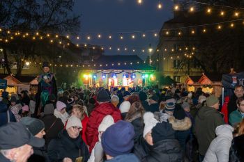 udekorowany skwer, scena, występy, osoby biorące udział w spotkaniu, poczęstunek, karuzela, żywa szopka