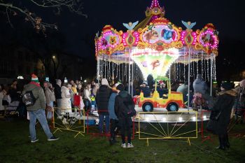 udekorowany skwer, scena, występy, osoby biorące udział w spotkaniu, poczęstunek, karuzela, żywa szopka