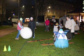 udekorowany skwer, scena, występy, osoby biorące udział w spotkaniu, poczęstunek, karuzela, żywa szopka
