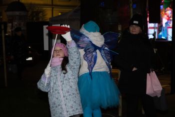 udekorowany skwer, scena, występy, osoby biorące udział w spotkaniu, poczęstunek, karuzela, żywa szopka