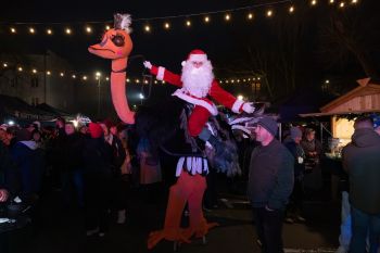 udekorowany skwer, scena, występy, osoby biorące udział w spotkaniu, poczęstunek, karuzela, żywa szopka