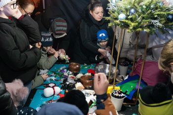 udekorowany skwer, scena, występy, osoby biorące udział w spotkaniu, poczęstunek, karuzela, żywa szopka