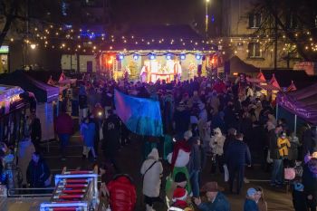 udekorowany skwer, scena, występy, osoby biorące udział w spotkaniu, poczęstunek, karuzela, żywa szopka