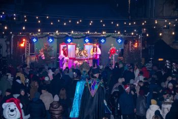 udekorowany skwer, scena, występy, osoby biorące udział w spotkaniu, poczęstunek, karuzela, żywa szopka