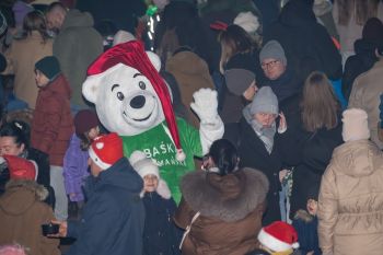 udekorowany skwer, scena, występy, osoby biorące udział w spotkaniu, poczęstunek, karuzela, żywa szopka