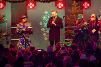 udekorowany skwer, scena, występy, osoby biorące udział w spotkaniu, poczęstunek, karuzela, żywa szopka