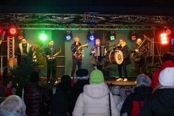 udekorowany skwer, scena, występy, osoby biorące udział w spotkaniu, poczęstunek, karuzela, żywa szopka