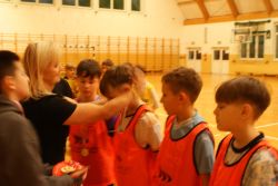 Kobieta zakłada chłopcu medal na szyję.