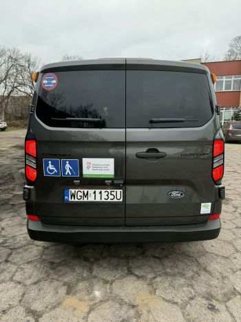samochód bus z naklejonym znakiem osób z niepełnosprawnościami i PFRON