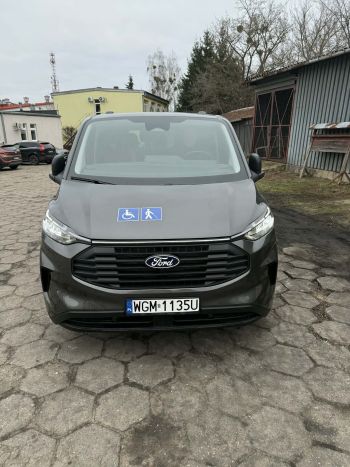 samochód bus z naklejonym znakiem osób z niepełnosprawnościami i PFRON