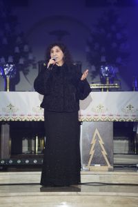 Kobieta z mikrofonem stojąca w kościele.