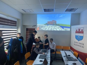 sala z rzutnikiem, burmistrz wręcza dyplomy dzieciom