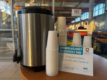 termos z gorącą herbatą obok tabliczka z napisem