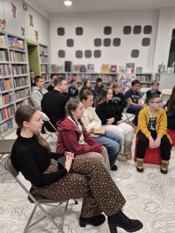 sala w bibliotece, zebrana młodzież siedzi na krzesełkach,