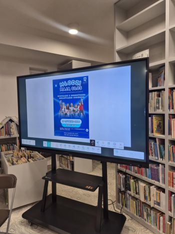 sala w bibliotece, zebrana młodzież siedzi na krzesełkach,