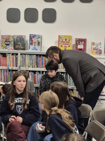 sala w bibliotece, zebrana młodzież siedzi na krzesełkach,
