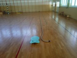 Lina i wózek transportowy na parkiecie.