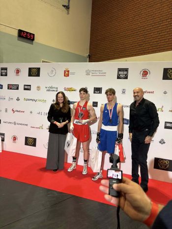 dwóch bokserów z dwoma innymi osobami pozujących na ściance reklamowej