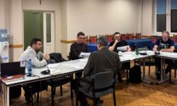 uczestnicy spotkania siedzą przy stole konferencyjnym,