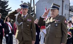 uroczystości pod pomnikiem, goście składający kwiaty, poczty sztandarowe szkół