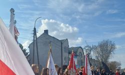 uroczystości pod pomnikiem, goście składający kwiaty, poczty sztandarowe szkół