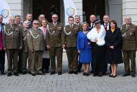 Pięć kobiet stojących w gronie kilkunastu żołnierzy.