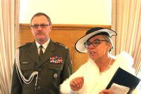 Kobieta w stroju z lat 20. XX wieku, obok mężczyzna w mundurze.