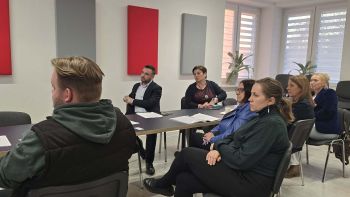 zebrani za spotkaniu siedzą na krzesłach