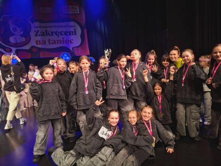 grupa zawodników ubranych na czarno na wspólnym zdjęciu, w rękach trzymają dyplomy