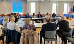 zebrani goście siedzący przy stole konferencyjnym,