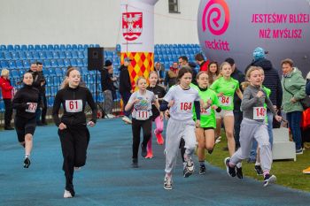 stadion miejski, biegające dzieci, piknik, wręczanie pucharów i medali