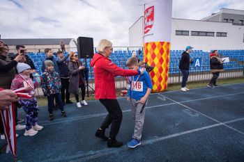 stadion miejski, biegające dzieci, piknik, wręczanie pucharów i medali