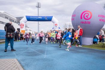 stadion miejski, biegające dzieci, piknik, wręczanie pucharów i medali