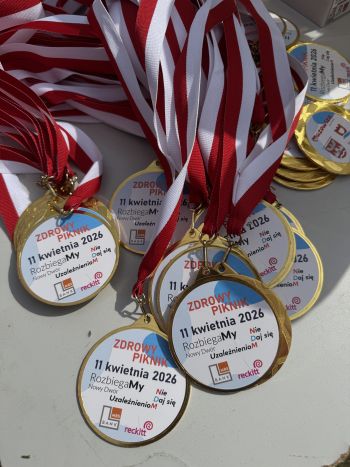 stadion miejski, biegające dzieci, piknik, wręczanie pucharów i medali