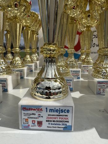 stadion miejski, biegające dzieci, piknik, wręczanie pucharów i medali