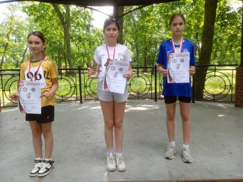 teren parku w Twierdzy Modlin, zawodnicy w strojach sportowych, wspólne zdjęcie z medalami, zwycięzcy na podium