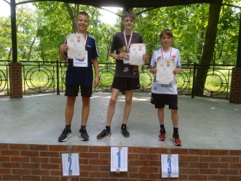 teren parku w Twierdzy Modlin, zawodnicy w strojach sportowych, wspólne zdjęcie z medalami, zwycięzcy na podium