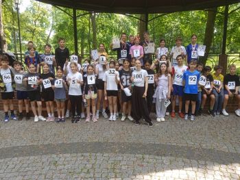 teren parku w Twierdzy Modlin, zawodnicy w strojach sportowych, wspólne zdjęcie z medalami, zwycięzcy na podium