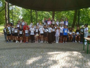 teren parku w Twierdzy Modlin, zawodnicy w strojach sportowych, wspólne zdjęcie z medalami, zwycięzcy na podium