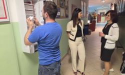 korytarz szkolny, mężczyzna stoi przy otwartym helpomacie - skrzyneczce