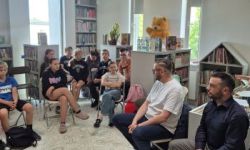 sala w bibliotece, zebrana młodzież siedzi na krzesełkach,