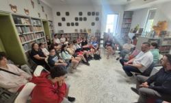 sala w bibliotece, zebrana młodzież siedzi na krzesełkach,