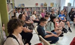 sala w bibliotece, zebrana młodzież siedzi na krzesełkach,