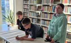 sala w bibliotece, zebrana młodzież siedzi na krzesełkach,
